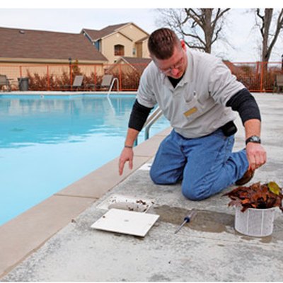 Man cleaning a swimming pool skimmer basket.