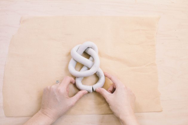 Closing tails of air dry clay sculpture to form a knot