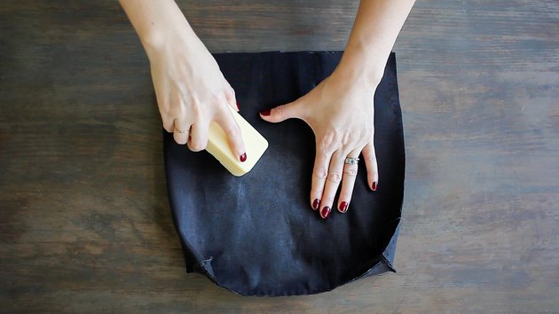 Rubbing bar of fabric wax onto fabric