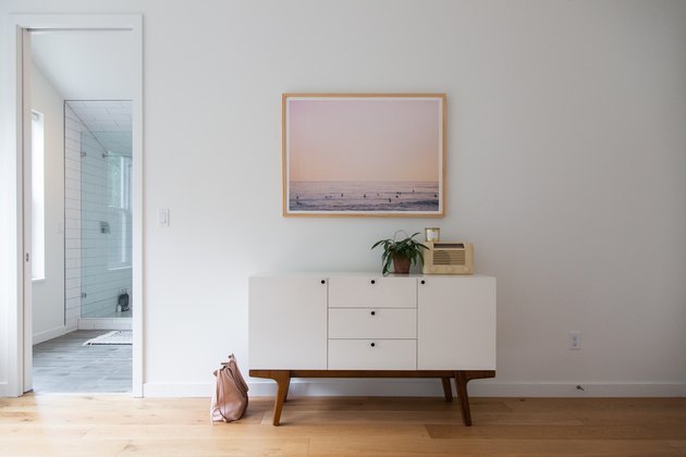minimalistic white credenza with white wall and hardwood flooring