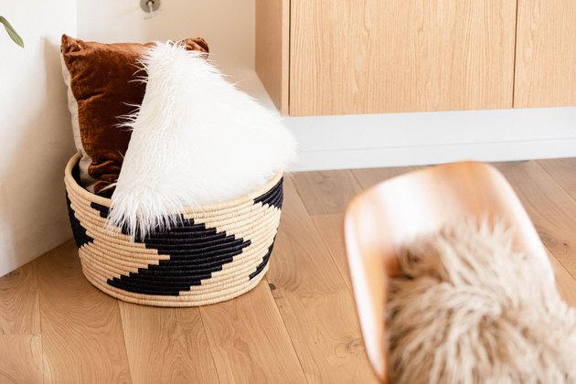 The Citizenry basket with pillows on a hardwood floor