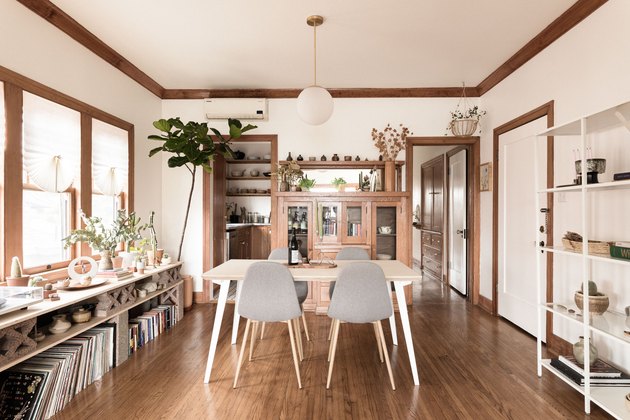 Hardwood dining room with wood trim, white walls and midcentury table