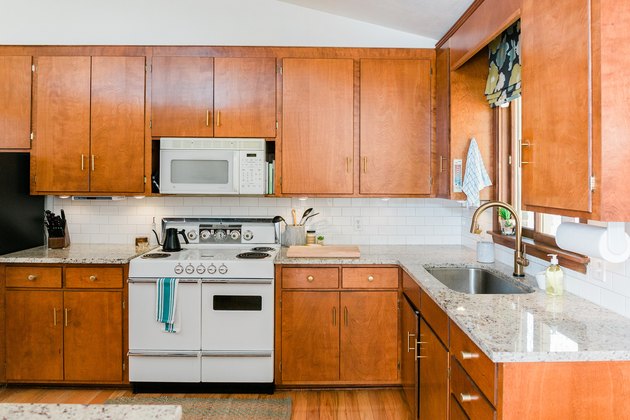 natural wood kitchen cabinets, countertop, sink, stove