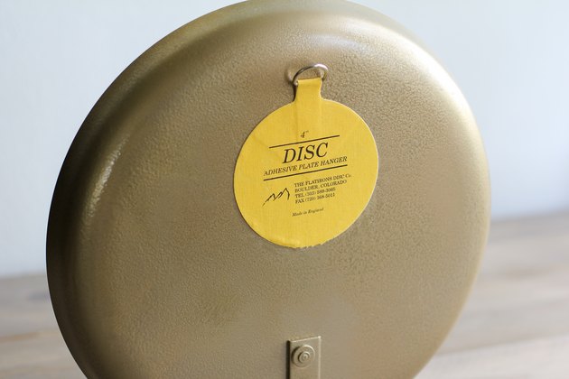 Adhesive plate hanger secured to back of platter