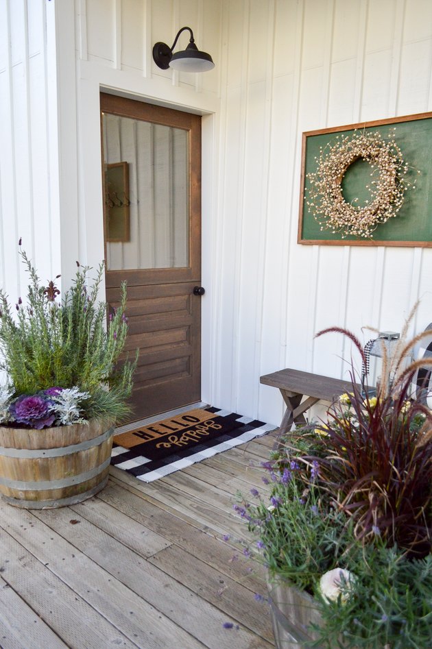 Farmhouse front door idea with flea market decor and potted plants