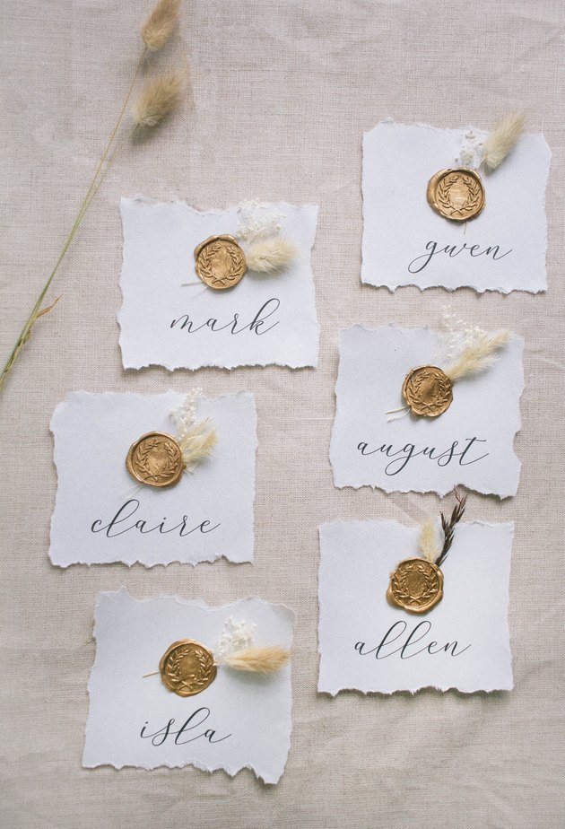 Six DIY gold wax seal place cards with dried flowers
