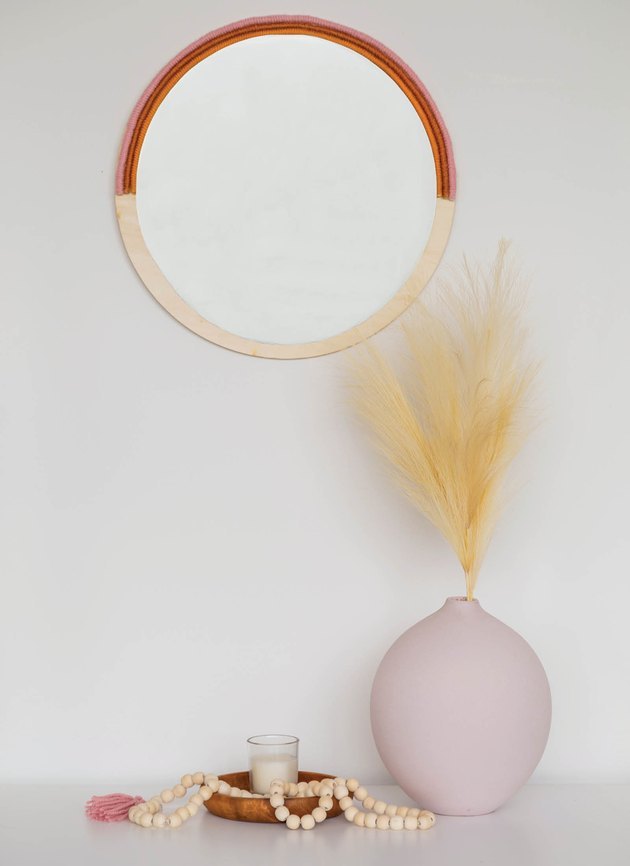 boho wall decor idea with yarn and wood mirror