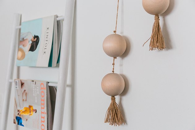 Hang the finished threaded beads on the wall using a hammer and picture hanging nails.