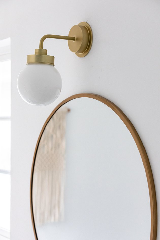 close up of bathroom light and circular mirror