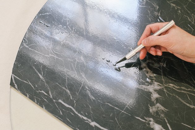 Poking hole in air bubble with utility knife