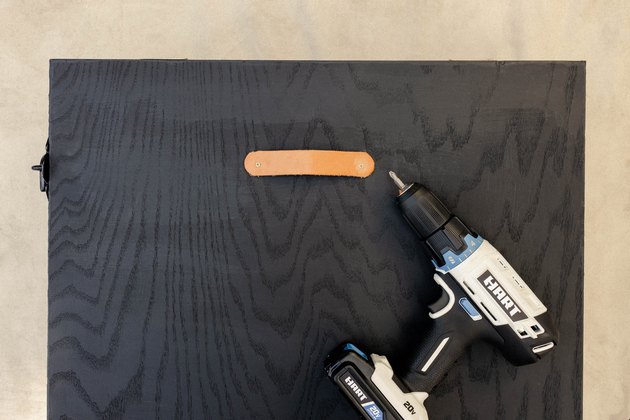 Leather drawer pull attached to front of cabinet with HART drill