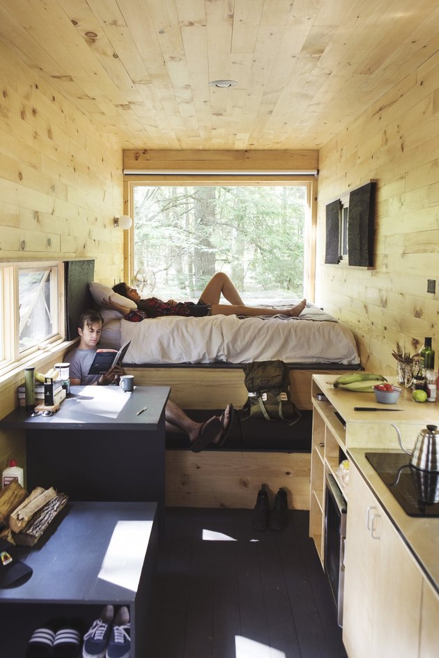 Two men reading in a tiny cabin.