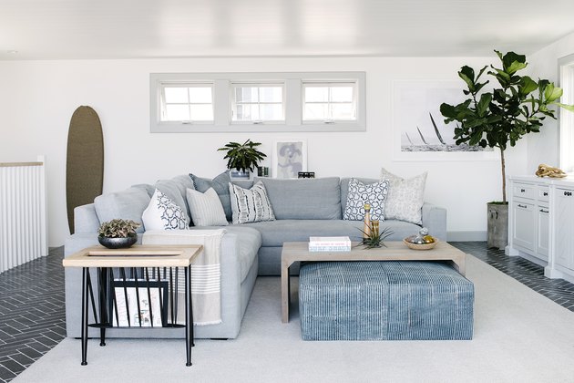 White and blue modern living room with sectional sofa and large ottoman