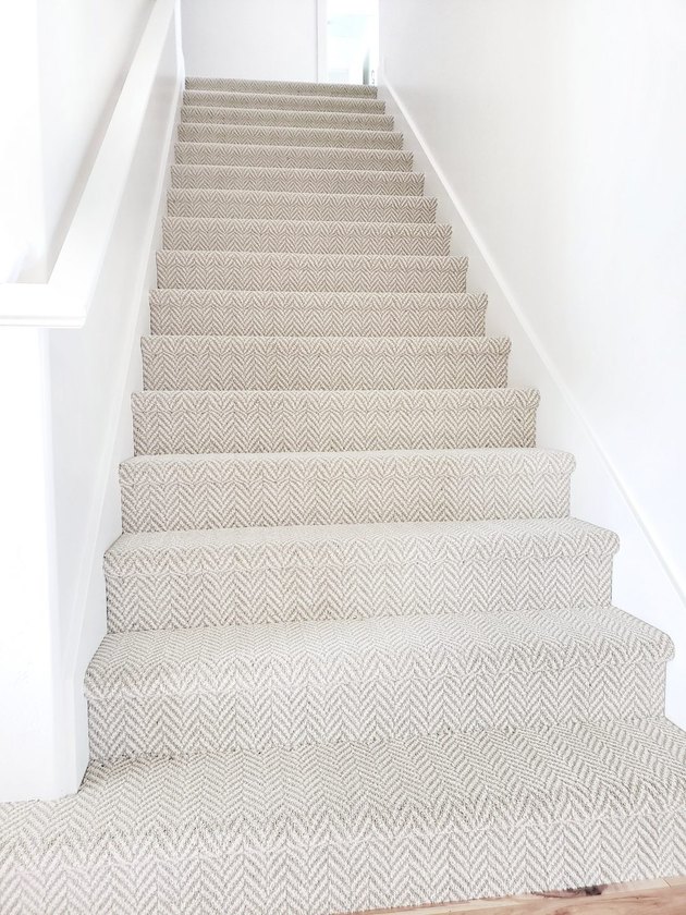 idée de tapis d'escalier neutre avec motif pied-de-poule dans un escalier blanc