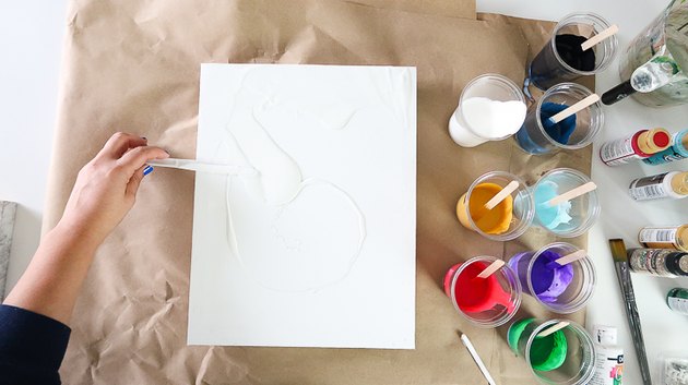 Spreading paint over canvas.