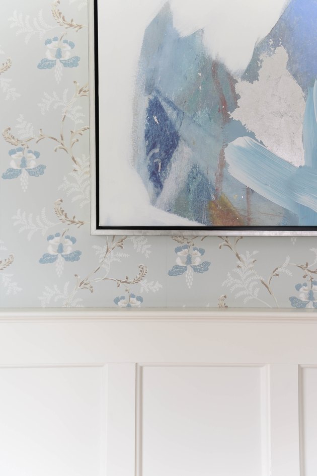 Modern artwork alongside blue and white floral wallpaper
