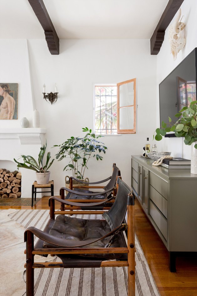 simple green living room idea with credenza for storage and leather lounge chairs with exposed ceiling beams