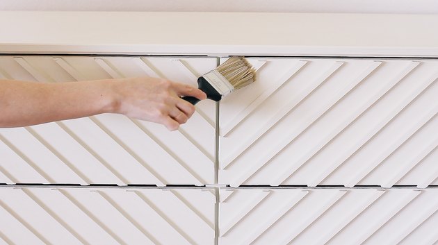 Applying clear protective finish on dresser