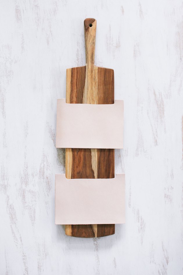 Arranging leather pouches on cutting board