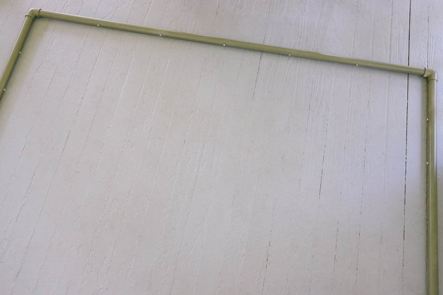 Two vertical PVC pipes attached to horizontal pipe with elbow connectors