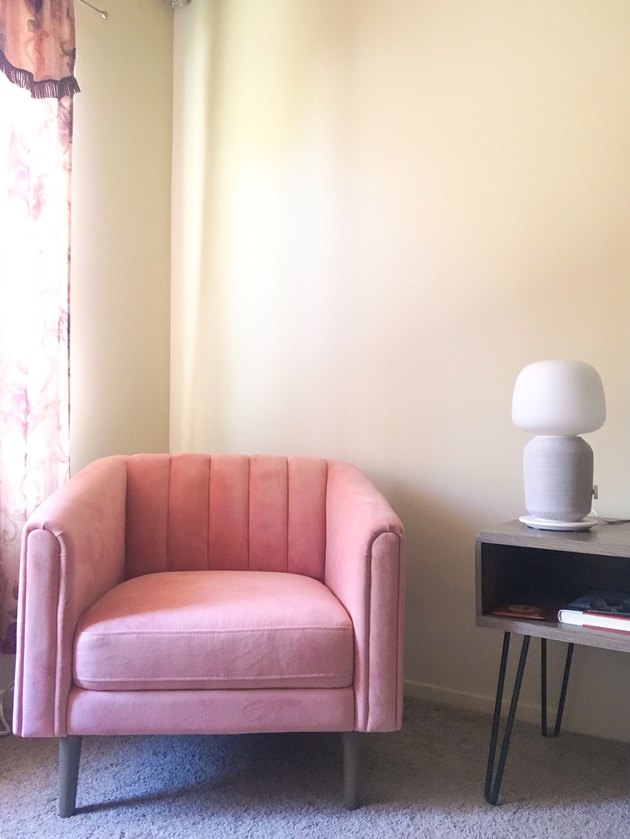 pink chair near lamp and tv stand