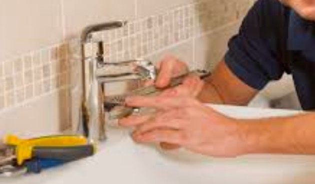 Plumber fixing faucet.