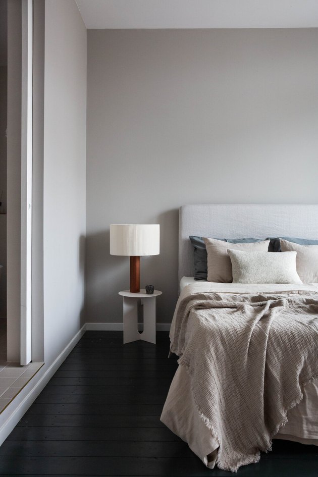 gray bedroom color idea with dark wood flooring