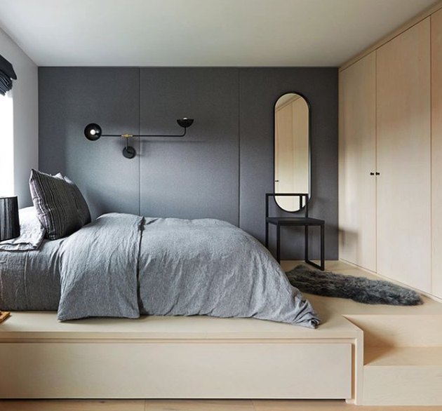 scandinavian bedroom with upholstered walls and light wood cabinetry and flooring
