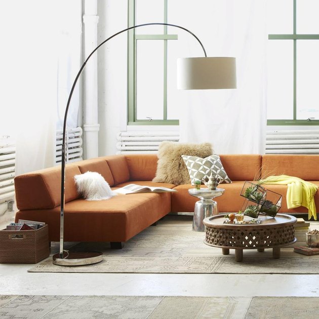 modern living room lighting idea with orange sofa and overarching lamp