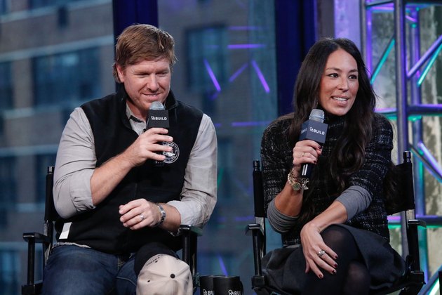 Chip and Joanna Gaines sitting in chairs holding microphones