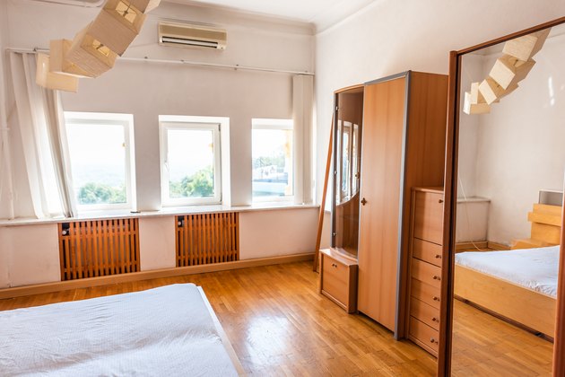 New clean white bed simple minimalist light wood wooden wardrobe cabinet closet or armoire in bedroom home house or apartment