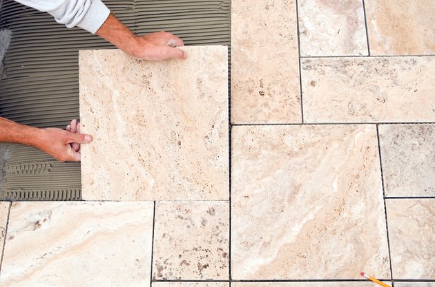 Worker Places New Tile on a Bathroom Floor