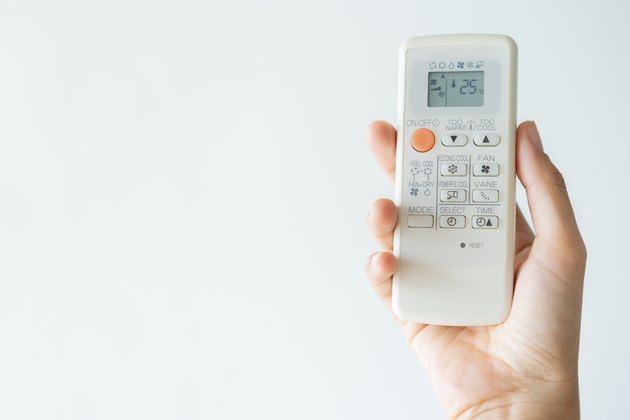 Woman hand using remote control open air conditioning 25 degrees. Open air 25 degrees, is temperature, save energy