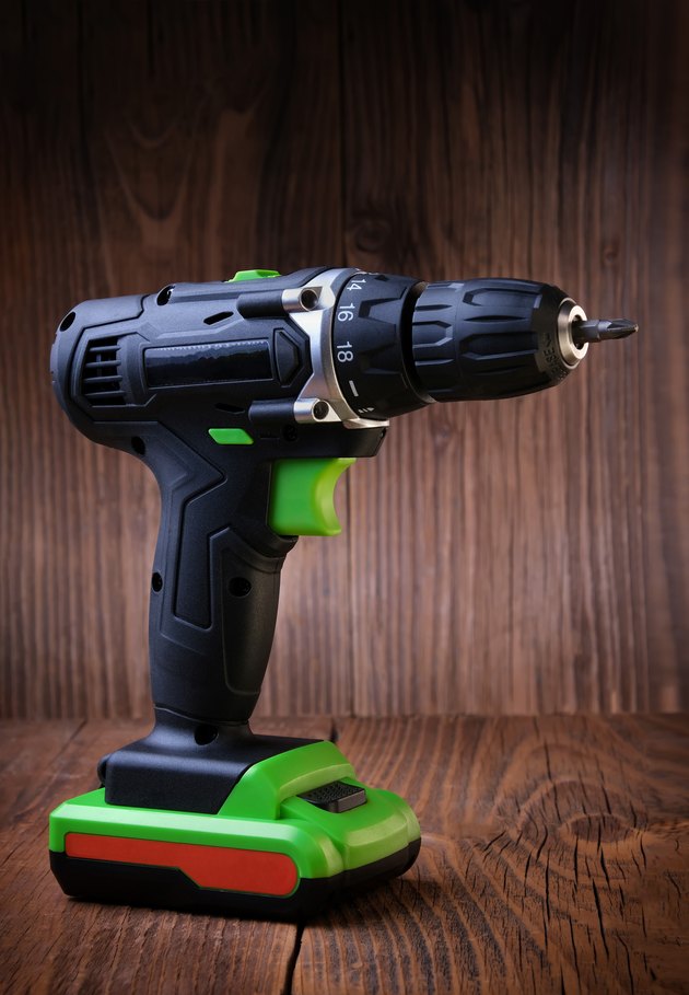 Electric screwdriver on rustic wooden background. cordless drill. maintenance home concept. Space for text.