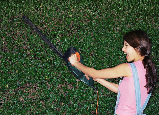 Woman with hedge trimmer.