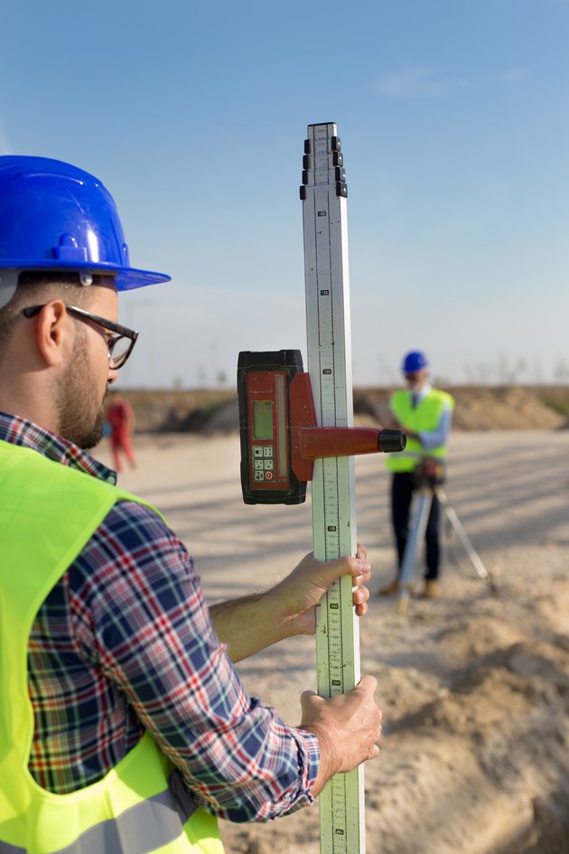 Worker with laser measuring tool