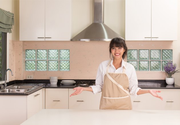 Beautiful young housekeeper cleaning the kitchen.