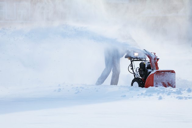 man with a snow blowing machine