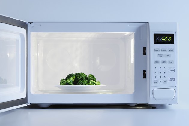 A small plate of broccoli inside a microwave