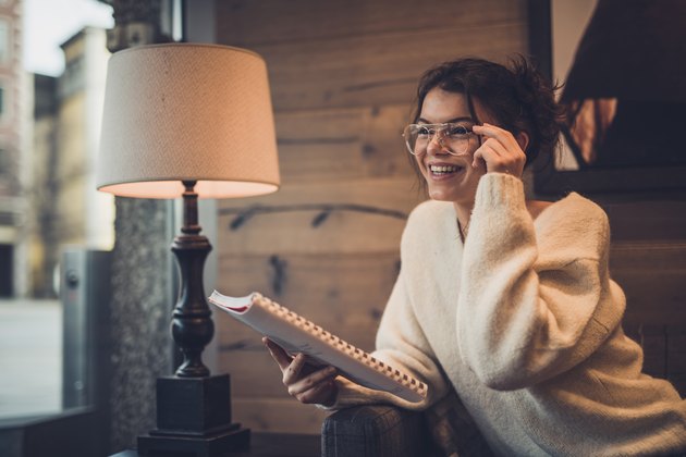 Young beautiful woman reading in restaurant.