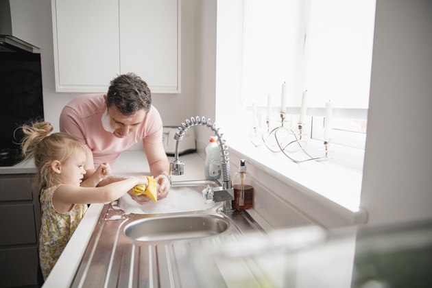 Father And Daughter Washing Dishes