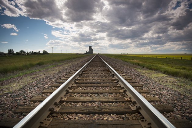 railroad tracks recede to the horizon, dark summer sky approaching