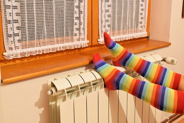 Central heating radiator and woman in striped socks