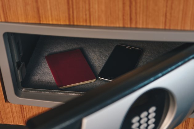 Close-Up Of Smart Phone And Passport In Safe