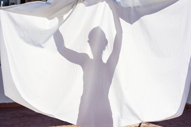 Shadow of woman hanging laundry
