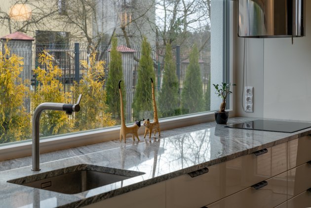 Detail of elegant kitchen furniture with decorative sculptures of cats near the window