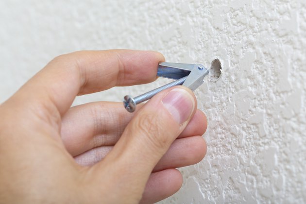 Inserting a toggle bolt.