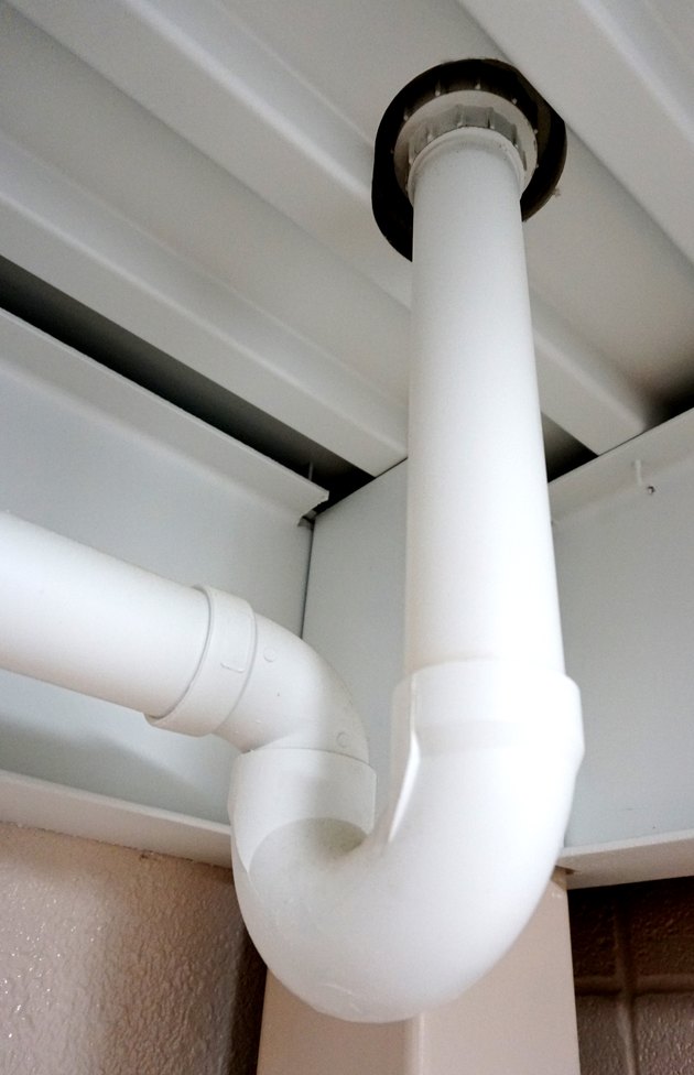 Looking up at a PVC pipe with a standard sewer trap
