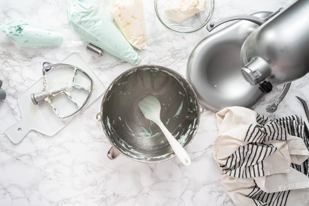 Making buttercream frosting for decorating a vanilla cake.