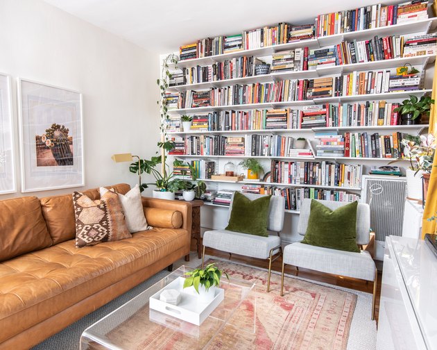book storage ideas in a living room with wall-to-wall shelving filled with books.